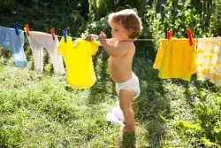 baby putting clothes on line